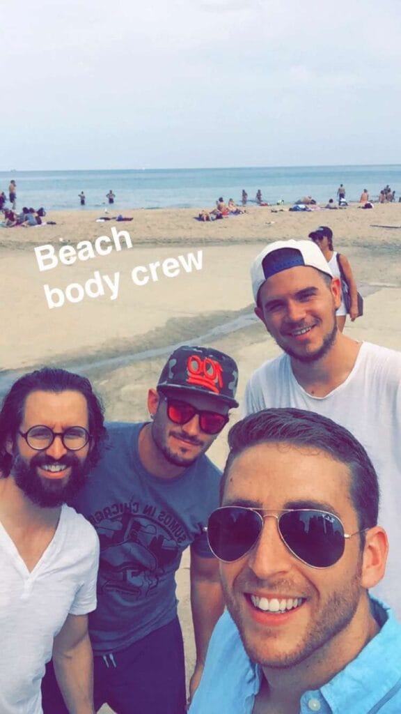 Bar Bruhis taking a selfie with three friends on a crowded beach, overlaid with the text Beach body crew
